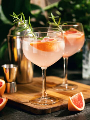 grapefruit cocktail sitting on wooden serving tray