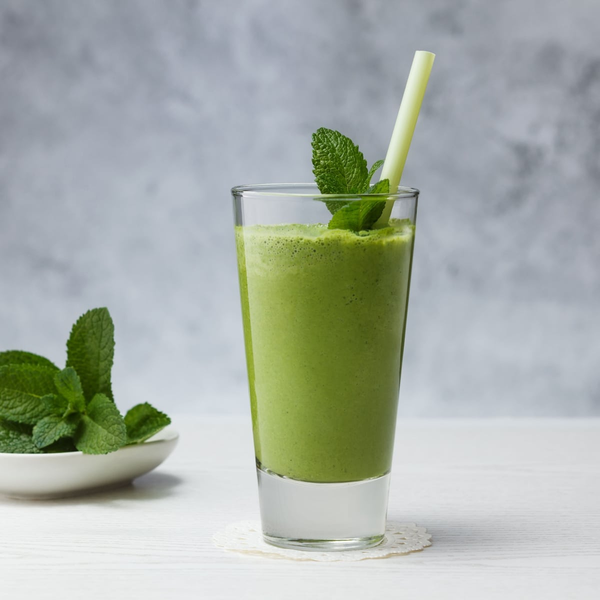 banana, avocado, spinach smoothie with fresh mint in clear glass