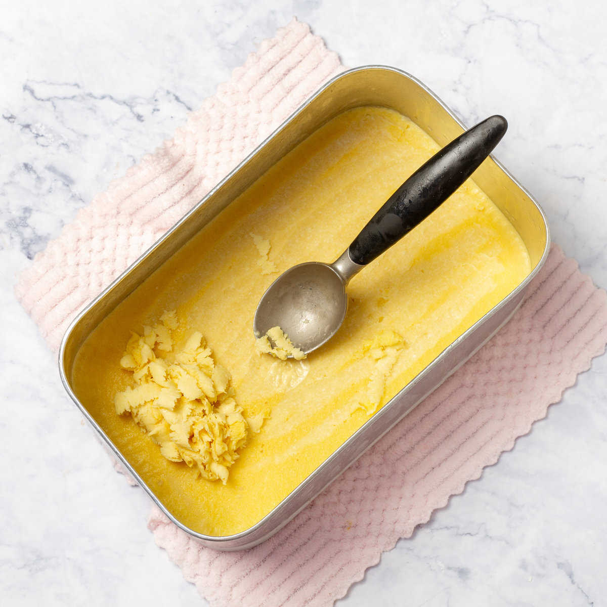 Creamy Mango and Coconut Ice Cream scrapped with spoon