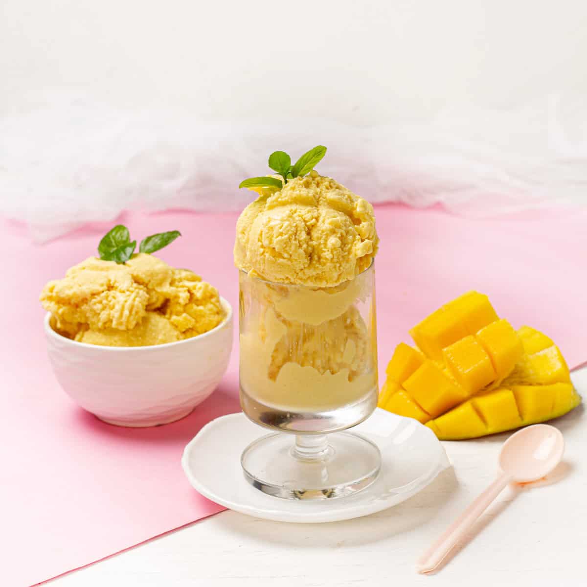 Creamy Mango and Coconut Ice Cream served in a bowl and glass with mango