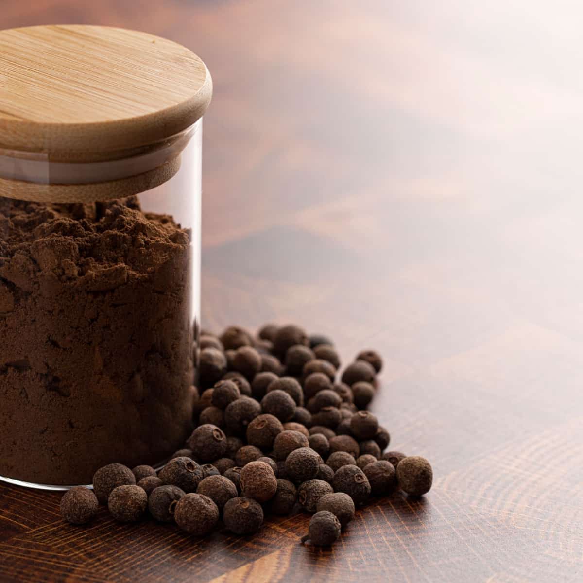 ground allspice in clear container on brown counter