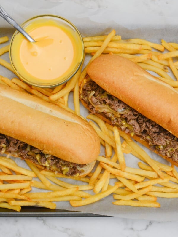 philly cheesesteak with fries on platter