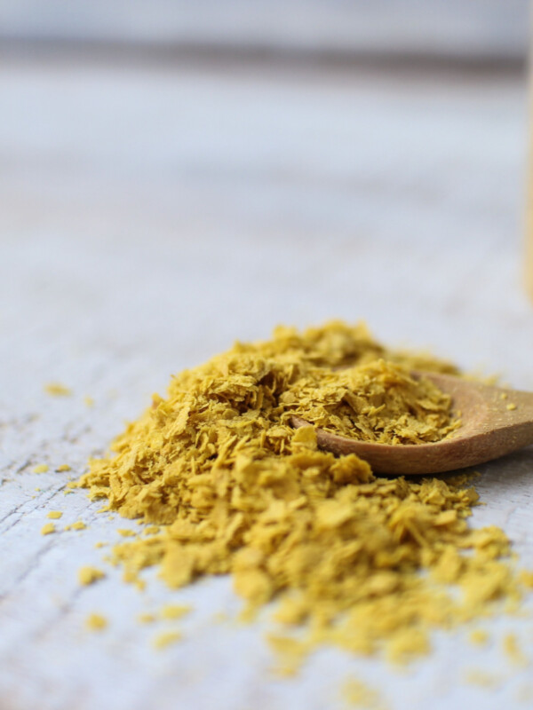 nutritional yeast on wooden spoon sitting on table