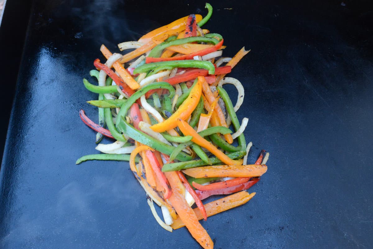 Vegetables have been scooped together into a pile. They are deeper in color, appear softer with some small charred bits