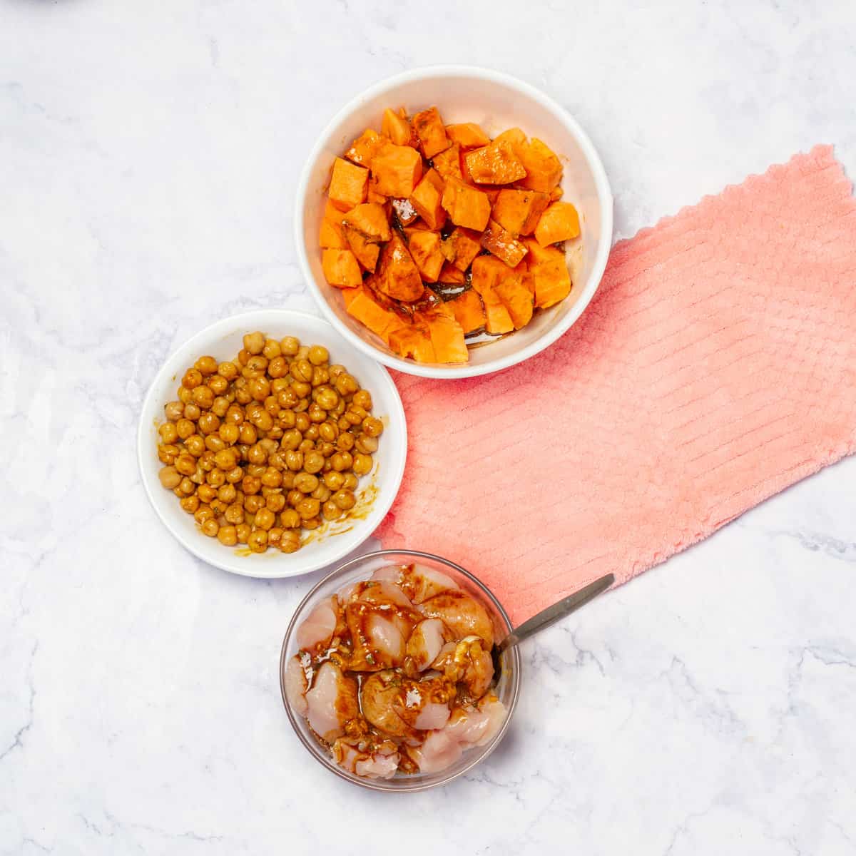 a bowl of marinated chicken cubes, chickpeas, and sweet potatoes