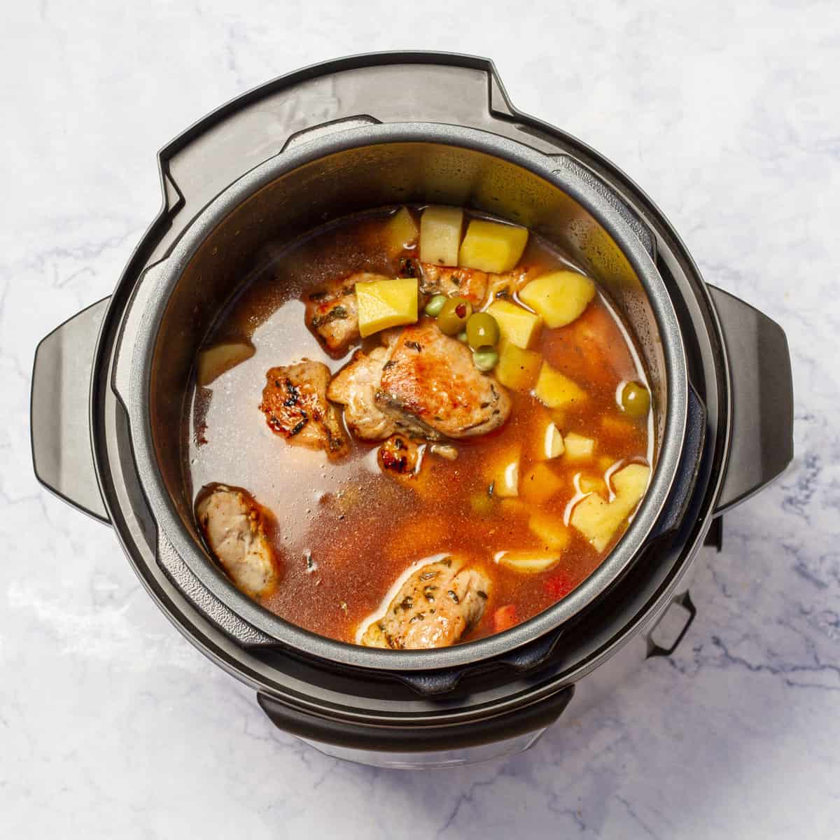Instant Pot Chicken Stew cooking with seared chicken to the pot