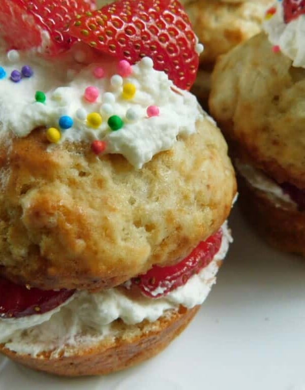 Strawberry shortcake muffins with fresh whip cream on a plate.