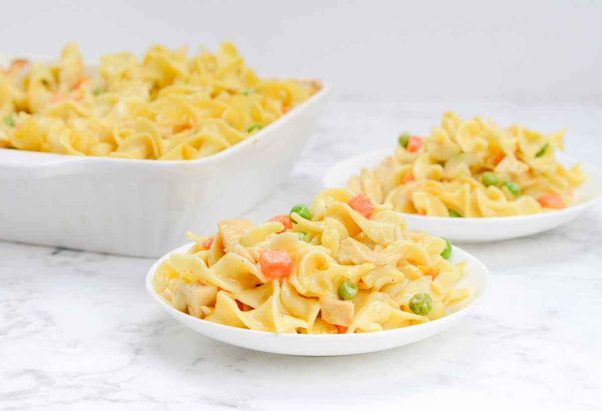 Two white plates of chicken noodle casserole
