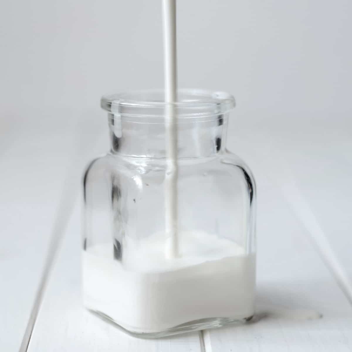 heavy cream pouring into clear jar