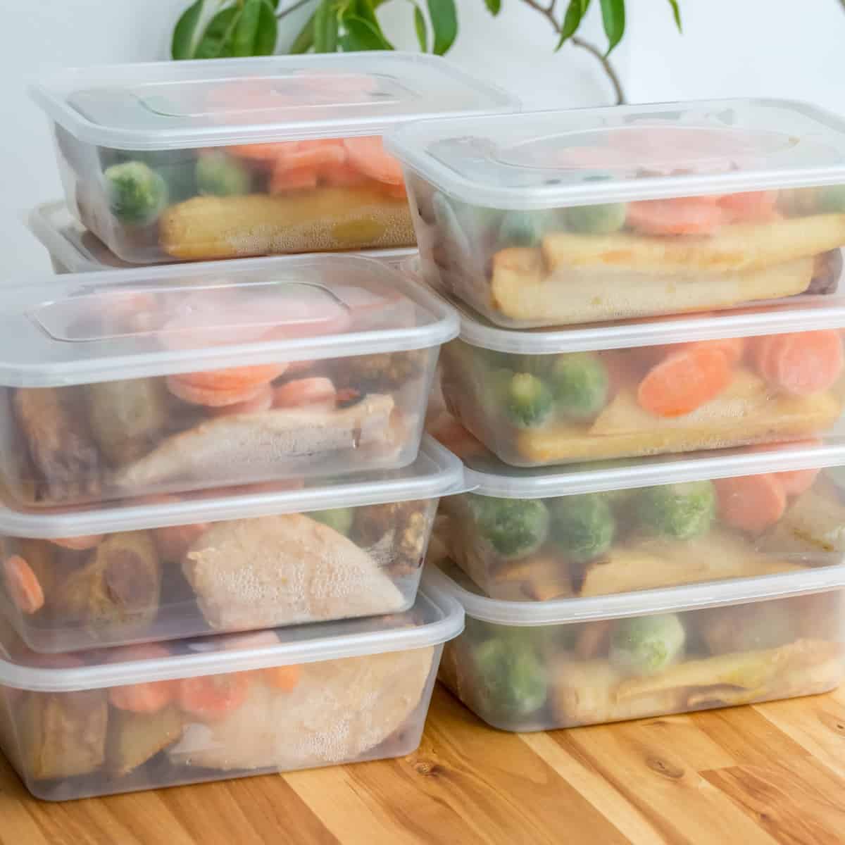 Meal prep containers stacked on cutting board
