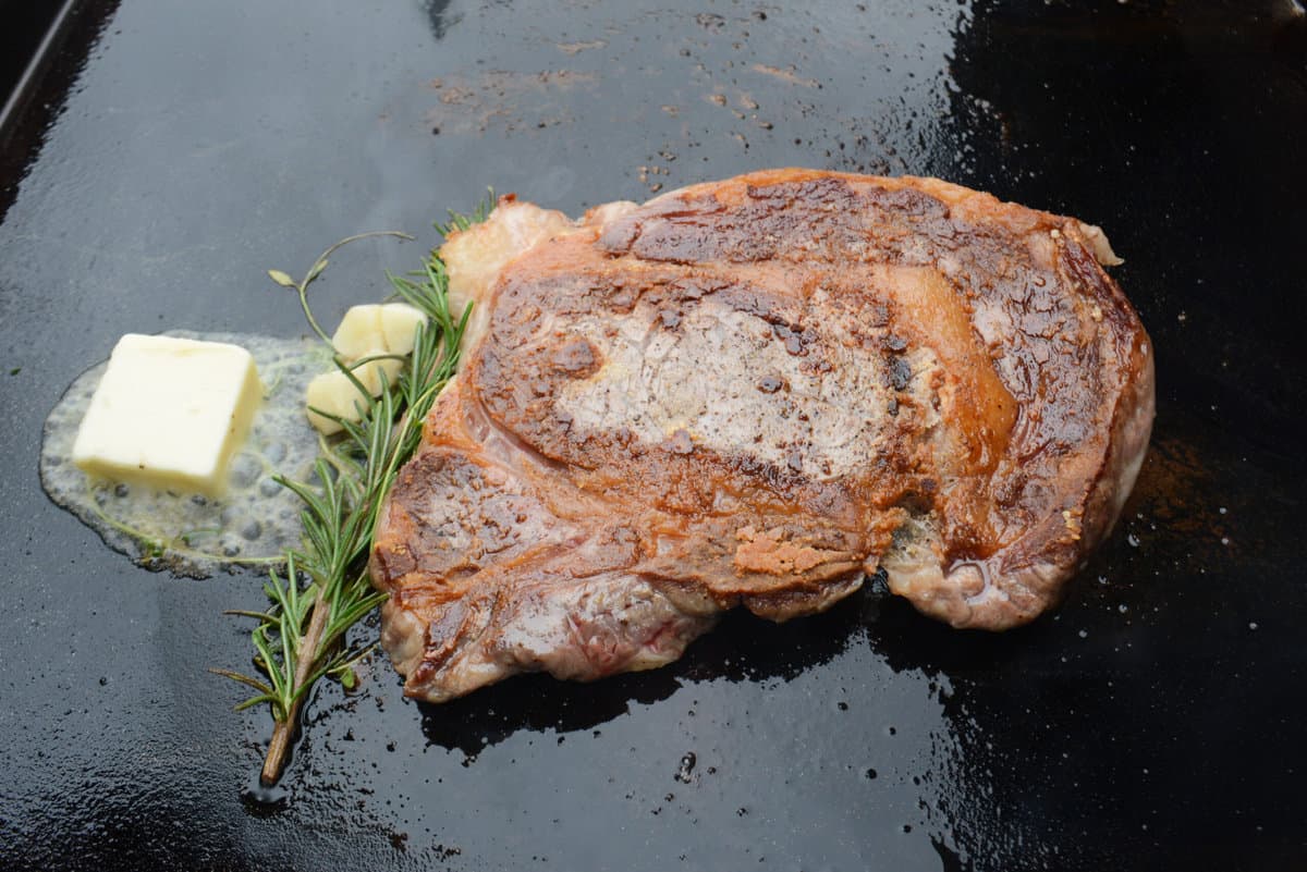 ribeye steak with butter and aromatics