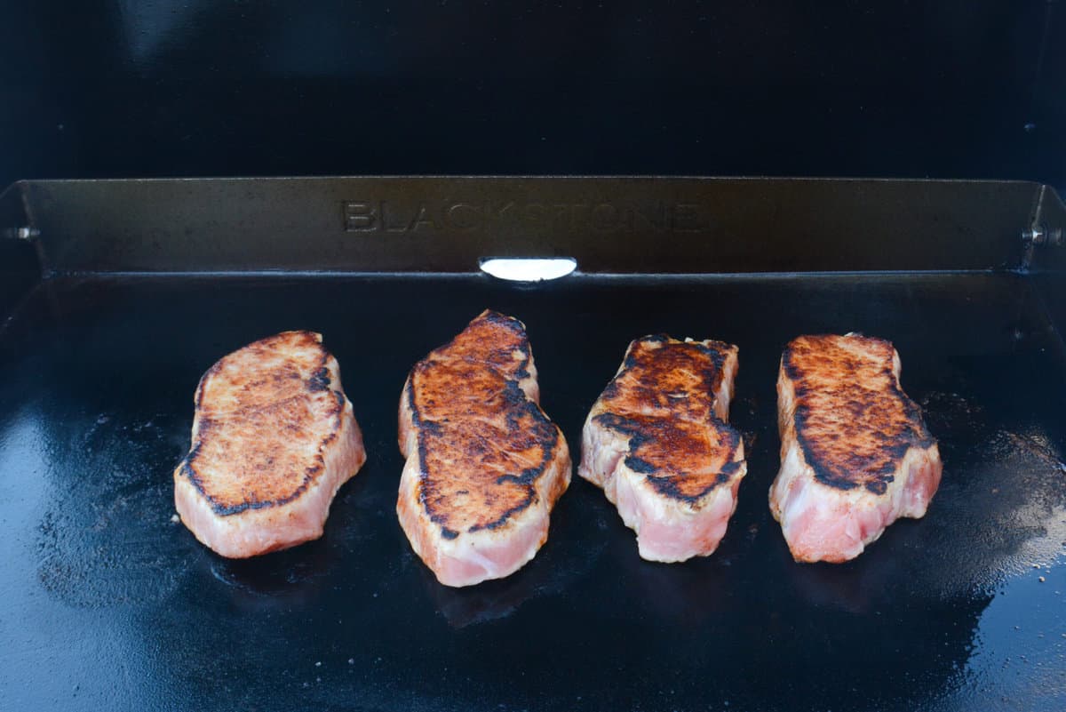 flipped blackstone pork chops, showing texture, sear and caramelization of dry rub
