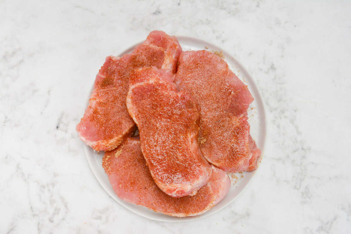 raw pork chops generously seasoned with dry rub