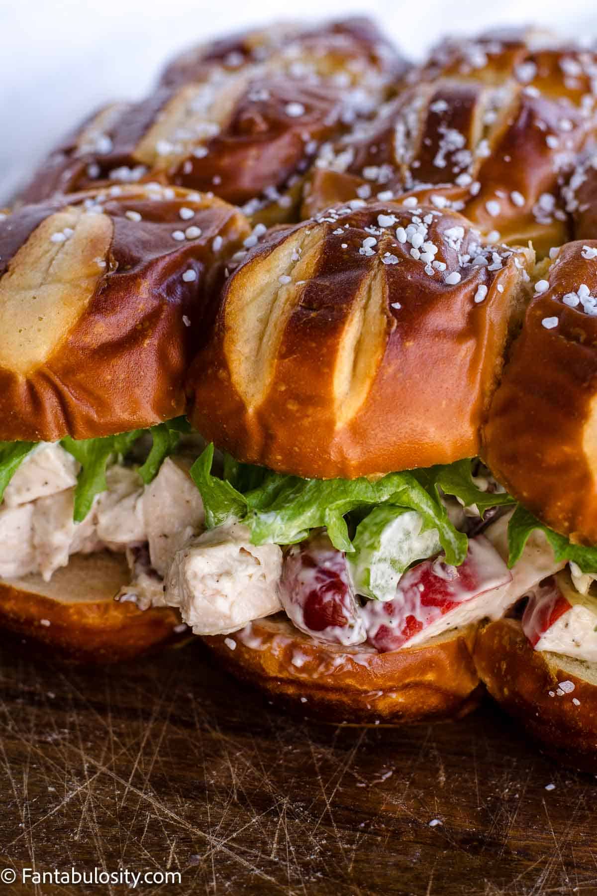 Chicken salad sliders with grapes and apples on a tray.