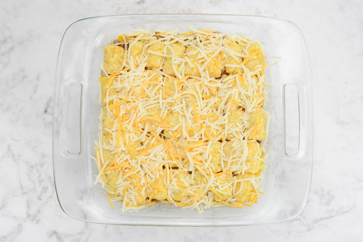 A casserole dish is shown completely assembled and topped with white and orange cheese