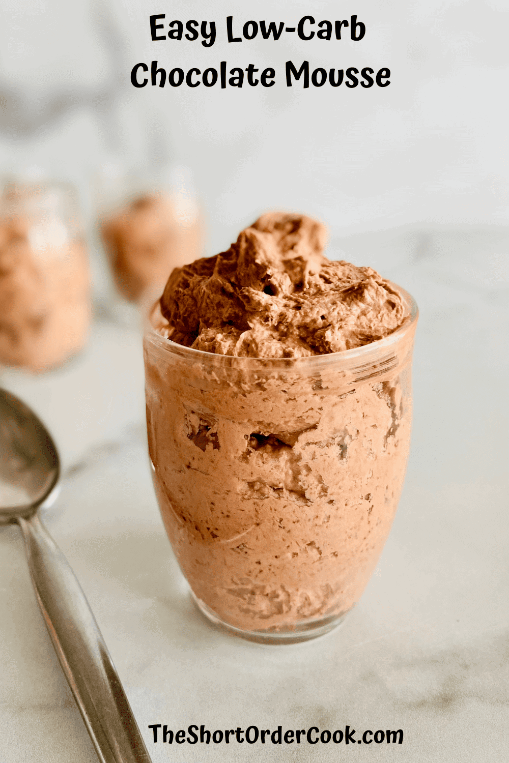 Chocolate mousse in a jar on a table with a spoon