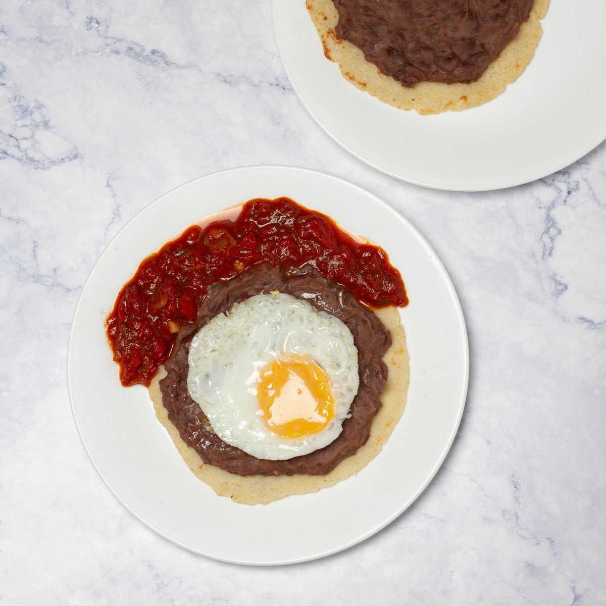 Spoon cooked beans onto each tortilla and topped with a fried egg