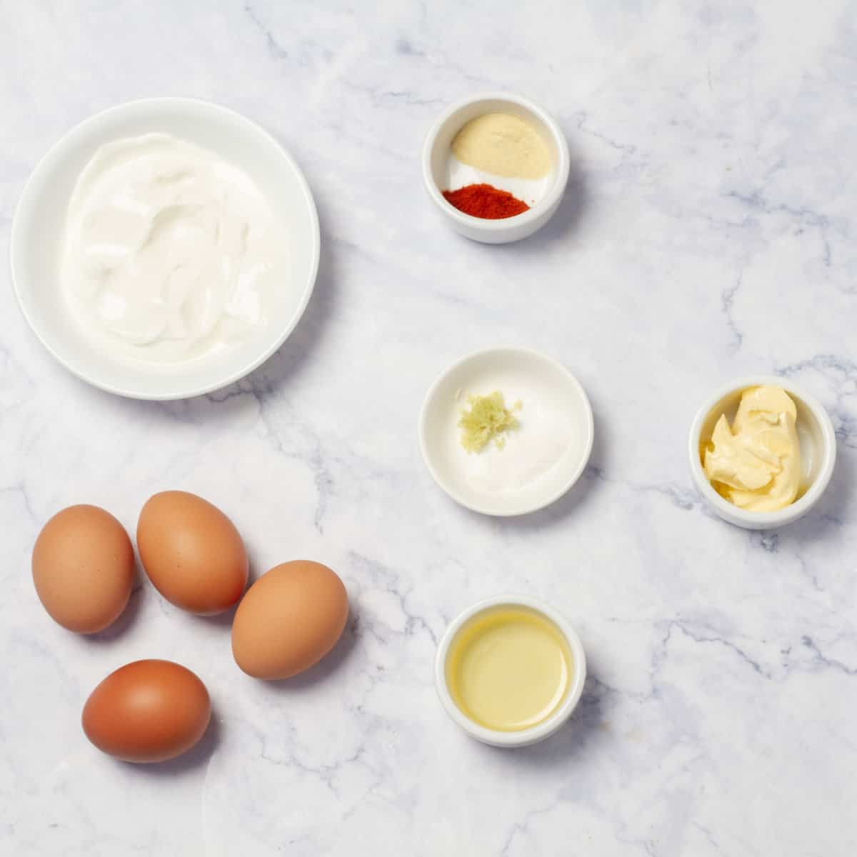 Cilber (Turkish poached eggs) ingredients of eggs, plain yogurt, paprika, garlic, lemon juice, paprika, buter, red pepper flakes, and salt. 