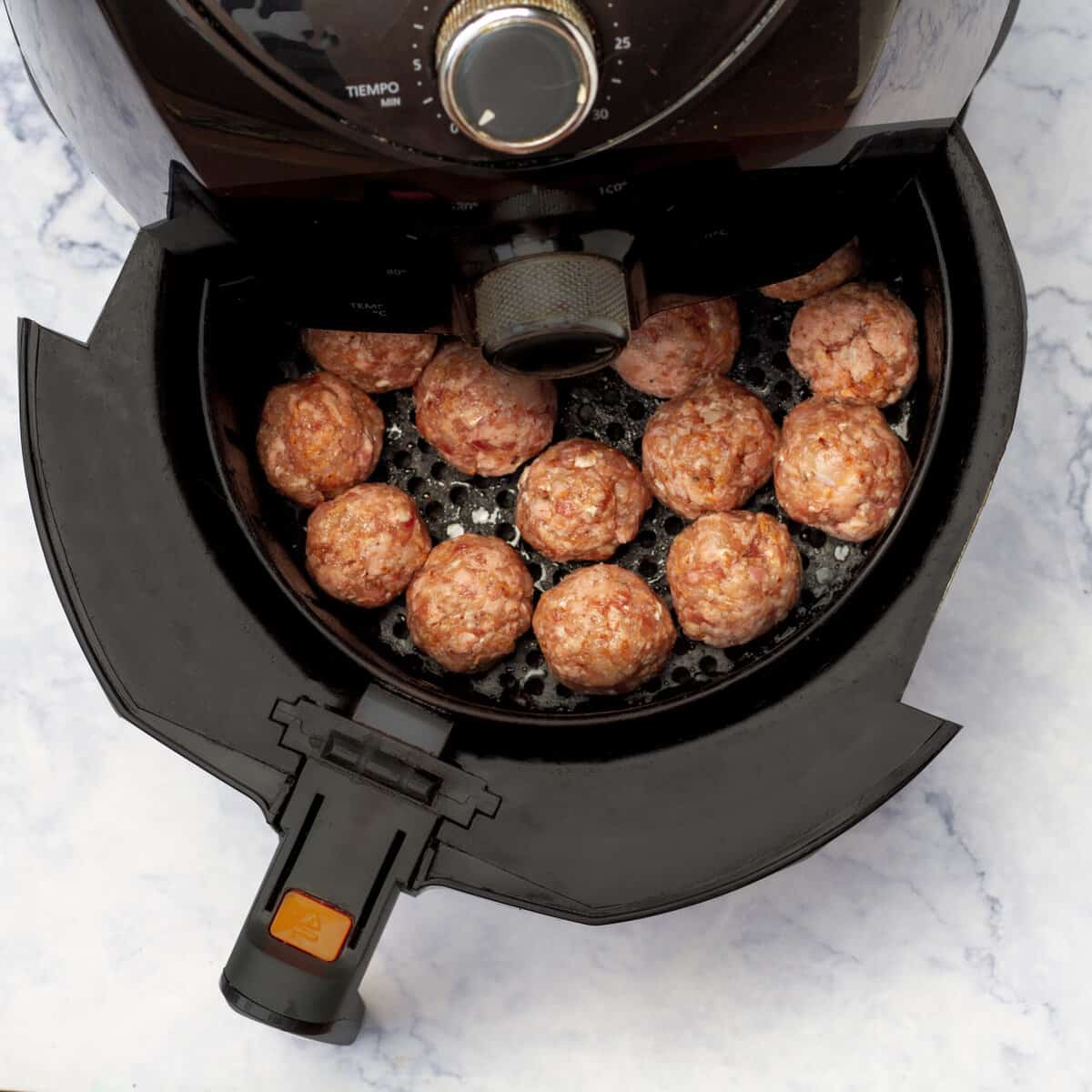 Small meatballs placed in a preheated air fryer basket