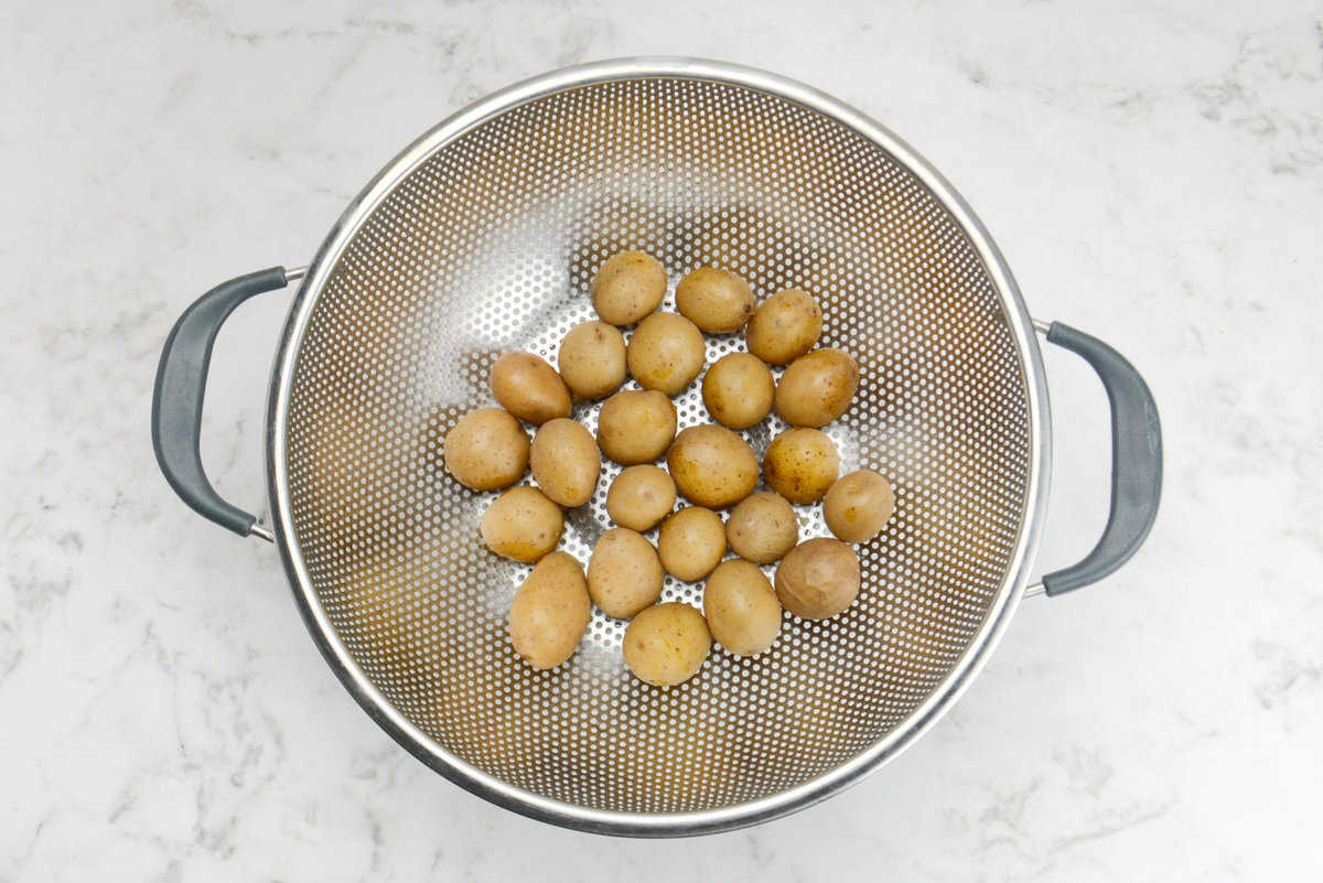 boiled and tender baby potatoes cooling in a strainer