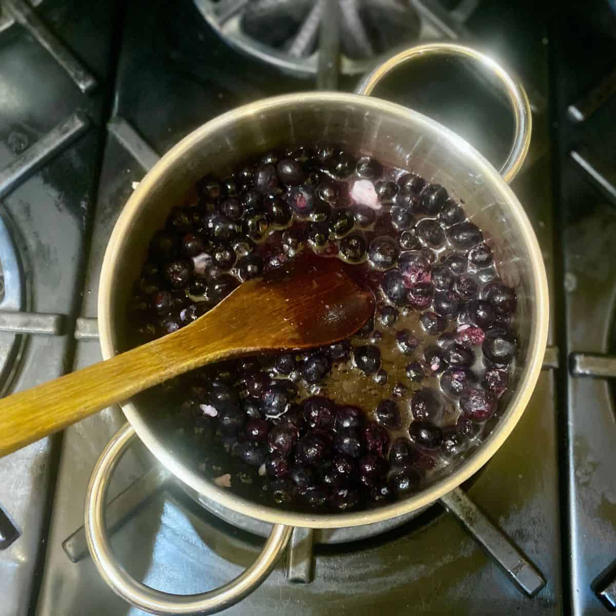 Cook the berries, lemon juice, and a pinch of salt in a pot until the berries break down. Stir as needed.