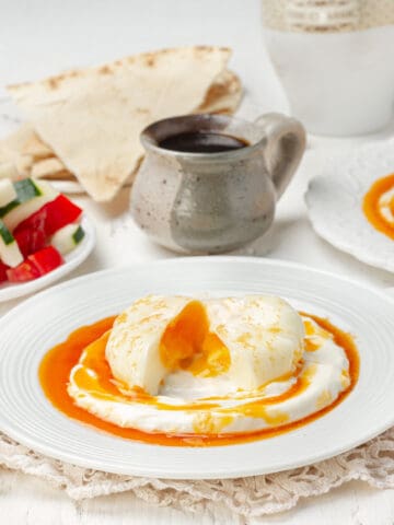 Cilbir, consisting of perfectly poached Turkish eggs atop a bed of plain yogurt and a rich lemon garlic butter sauce.