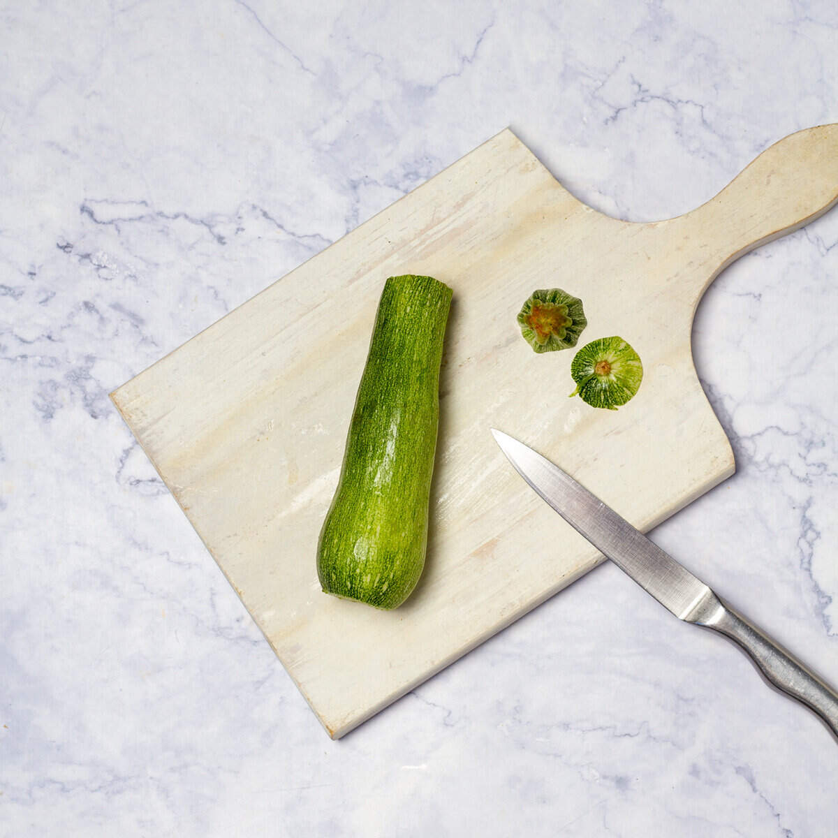 Zucchinis stem cut off on chopping board