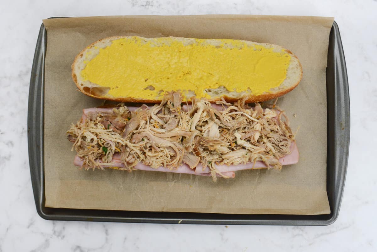 Sliced ham and shredded pork layered on top of the French bread. 