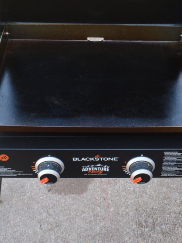 A Blackstone grill sits on a patio preheating