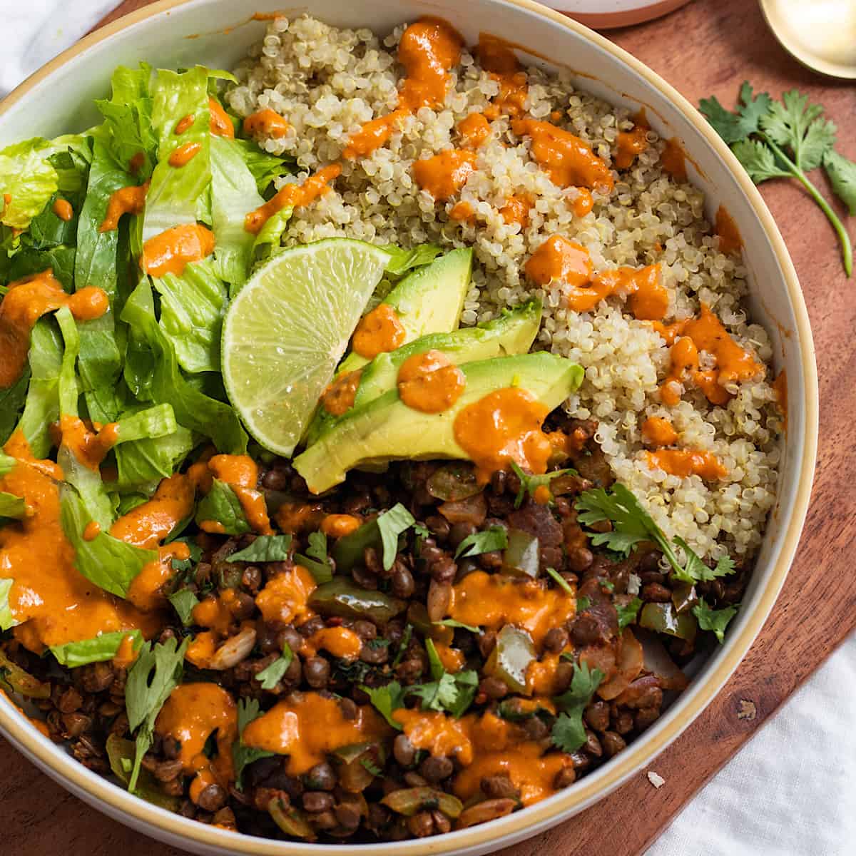 A Lentil Burrito Bowl on a wooden cutting bowl.