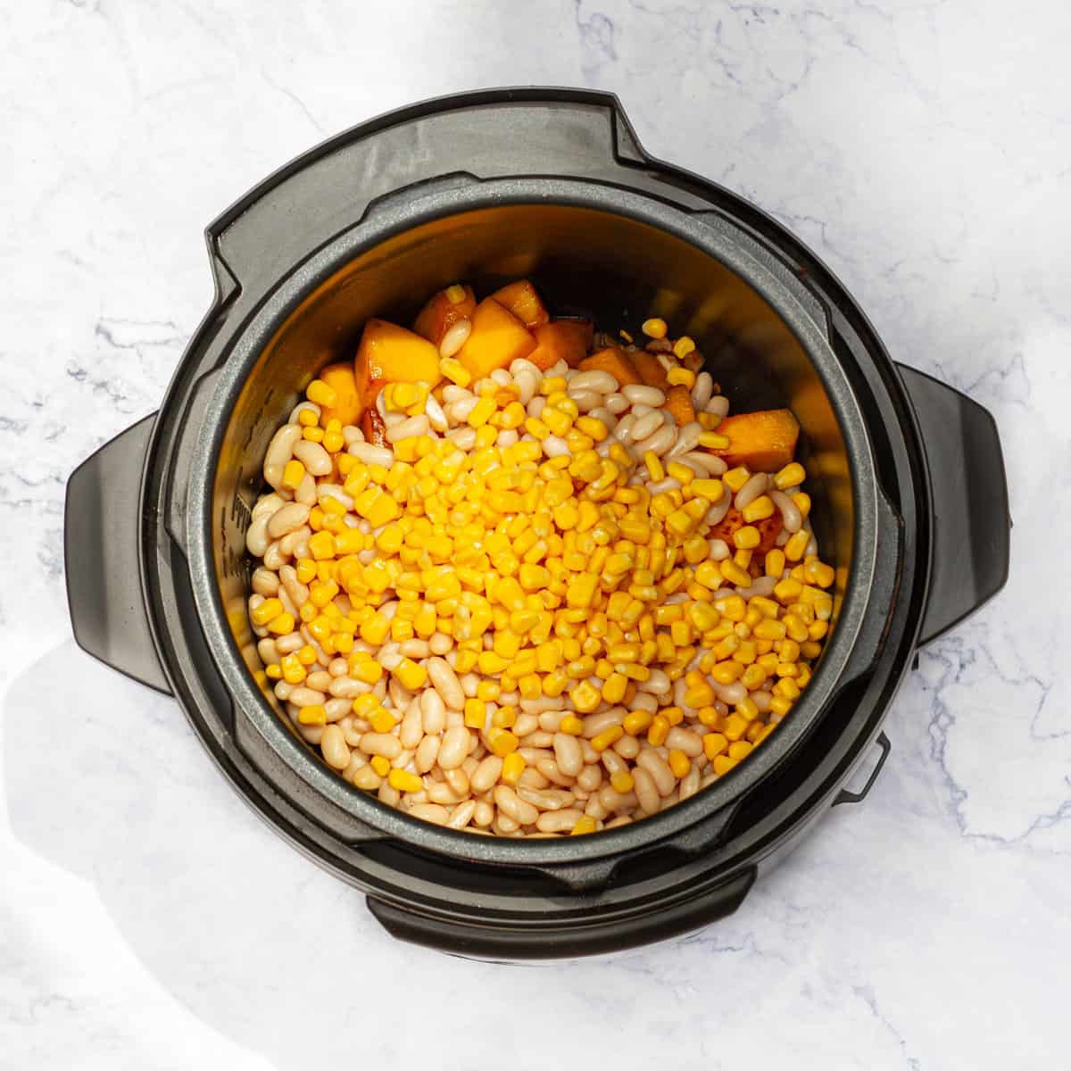 Add the cooked navy beans, corn kernels, diced pumpkin to the pot