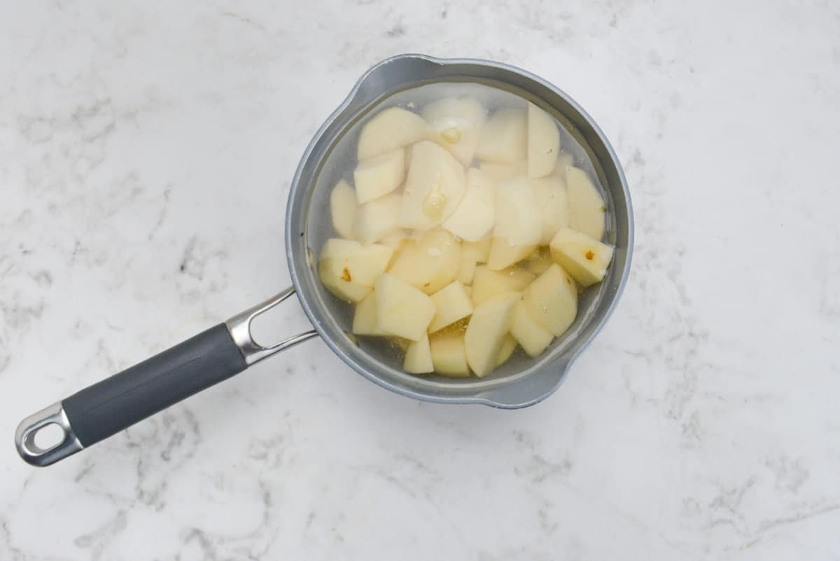 A small saucepan filled with salt, water, and potatoes 