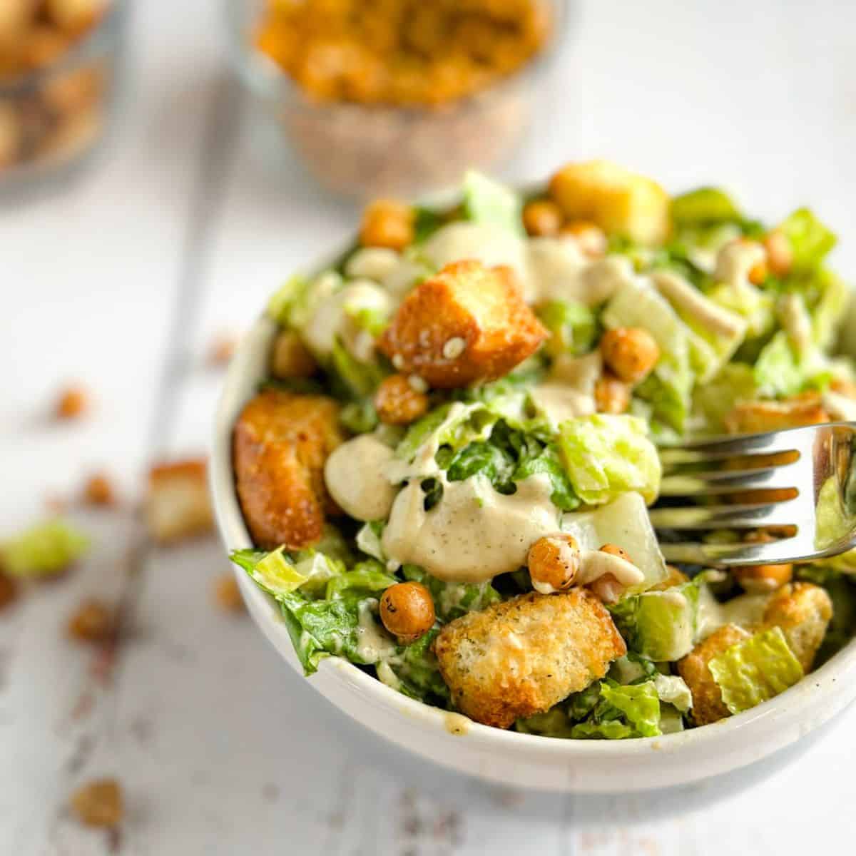 A Vegan Caesar Salad in a bowl with a fork.
