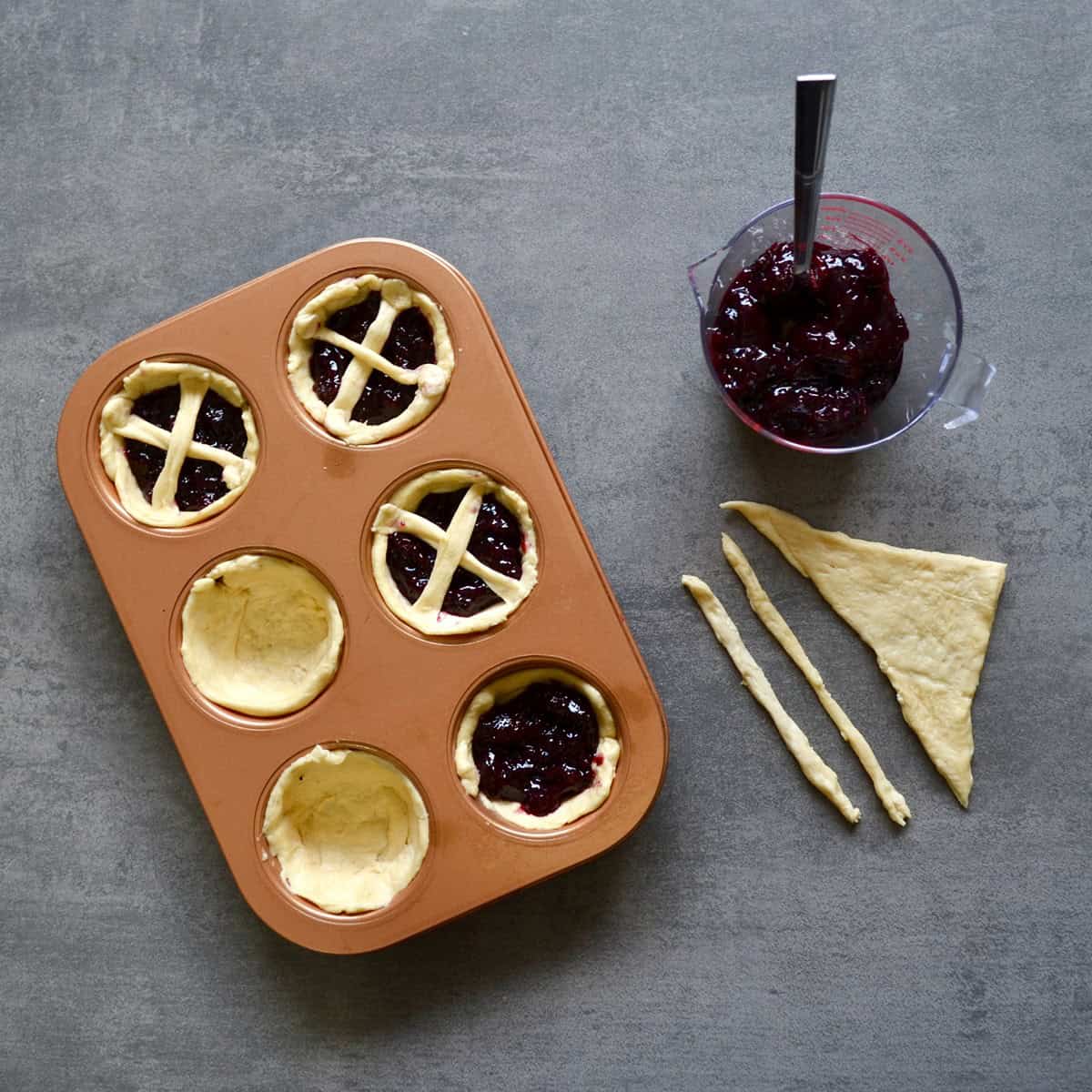 Assembling cherry pies in a muffin tin