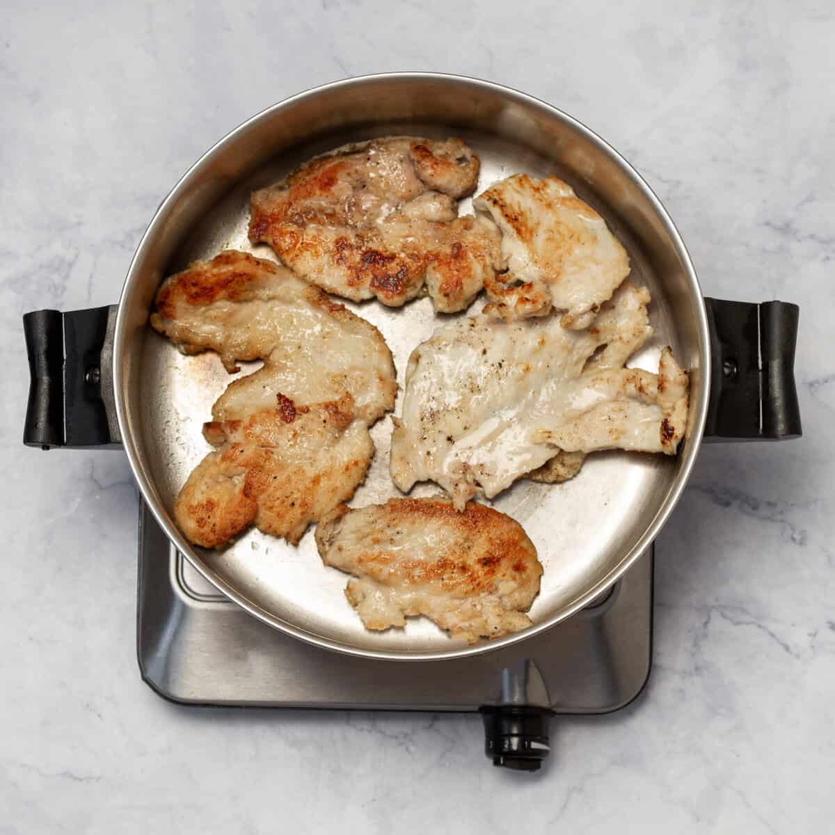 chicken breasts cooking brown in the skillet