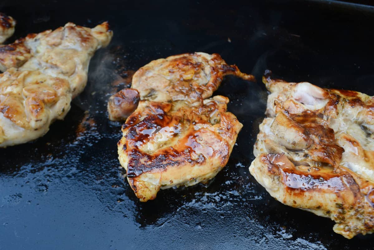 Close up of the glazed and browned cooked Blackstone chicken thighs with rising steam