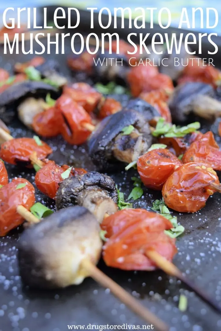 Grilled tomatoes and mushrooms on wooded skewers on a grill.