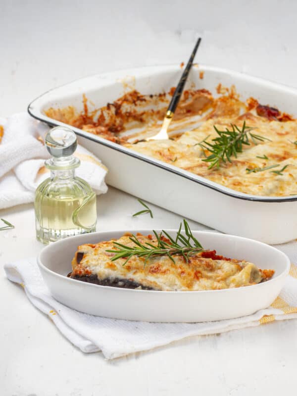 Eggplant Parmesan served in plate and baking tray