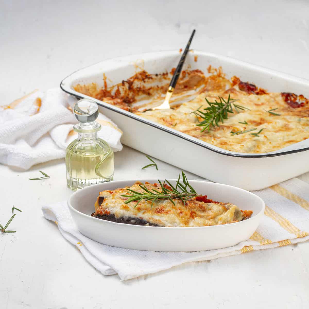 Eggplant Parmesan served in plate and baking tray