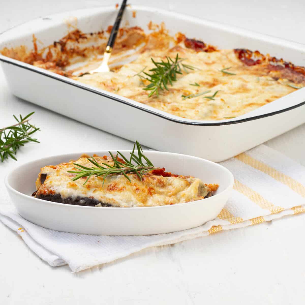 Eggplant Parmesan served in plate and baking tray