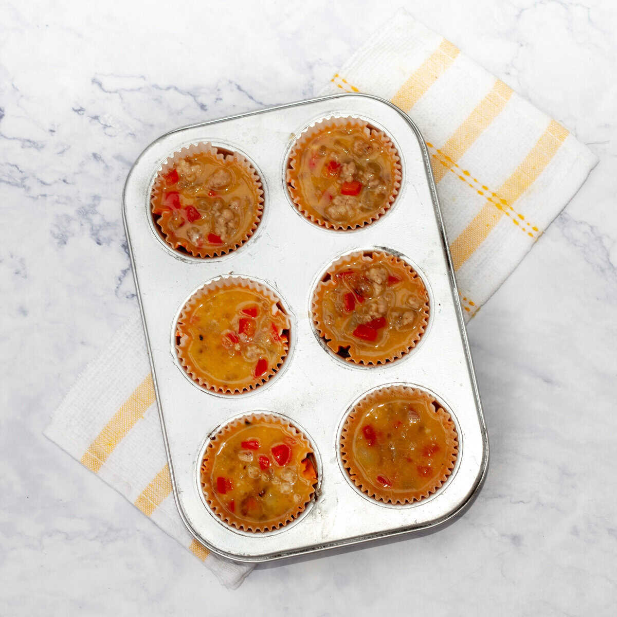 Pork eggs mixture added to muffin tin