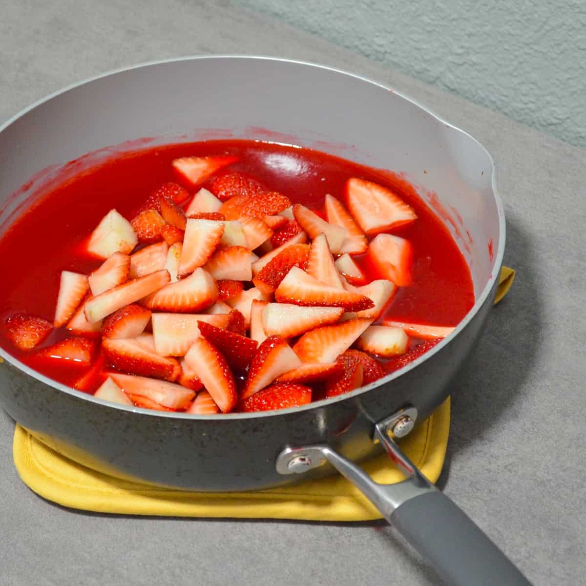 Skillet with jello mixture and strawberries