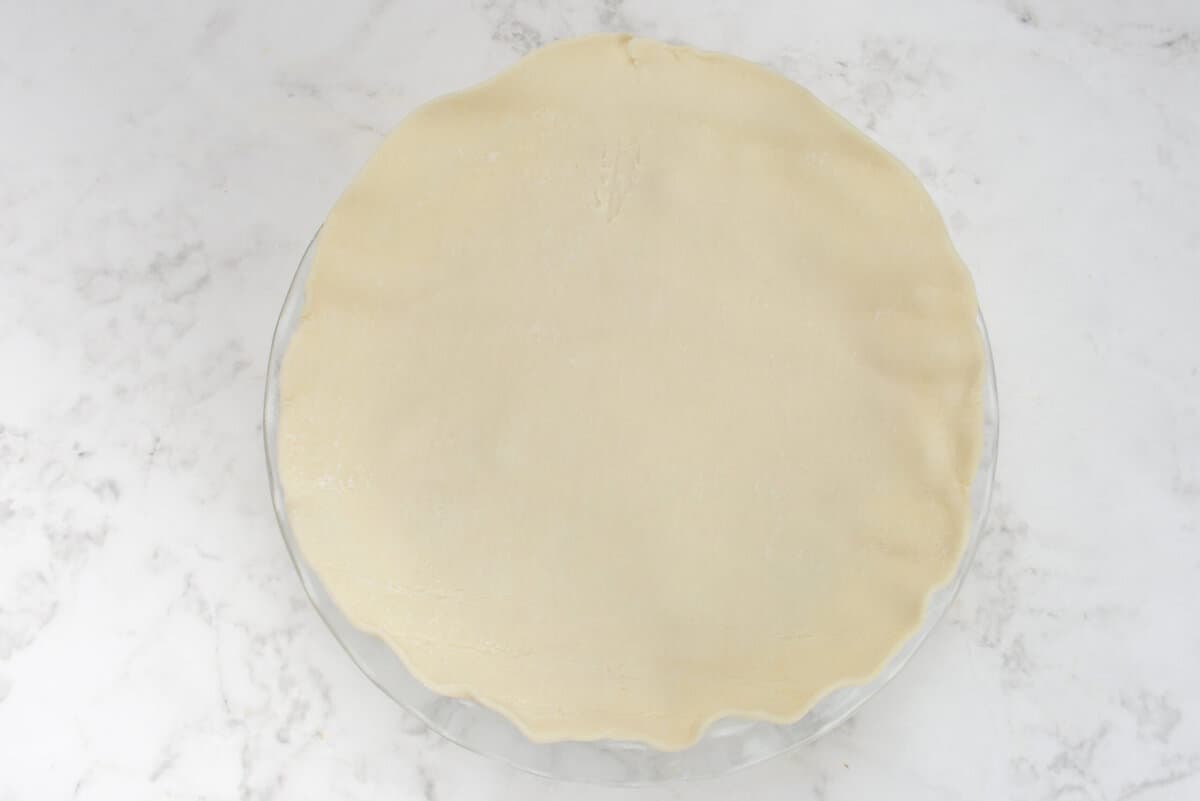 The unrolled pie crust covering the pie pan