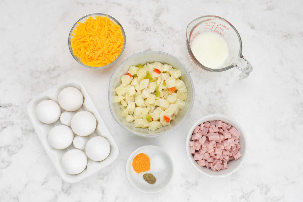 The ingredients to make the recipe in various sized bowls. The eggs are displayed in a white egg crate.