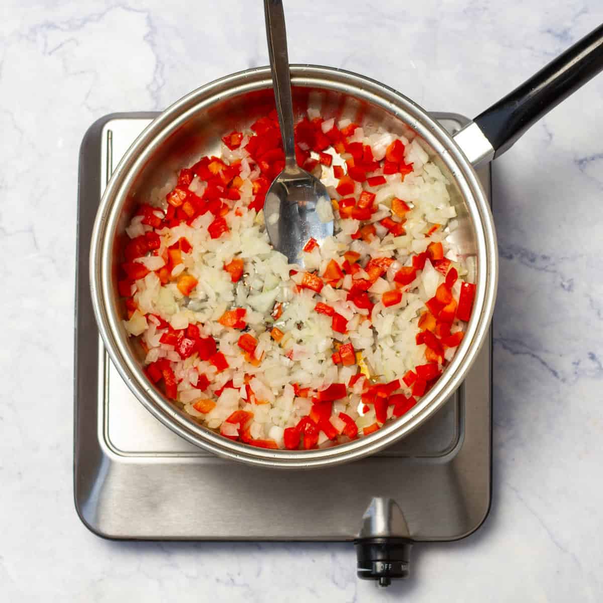 chopped onion and diced red bell pepper in skillet