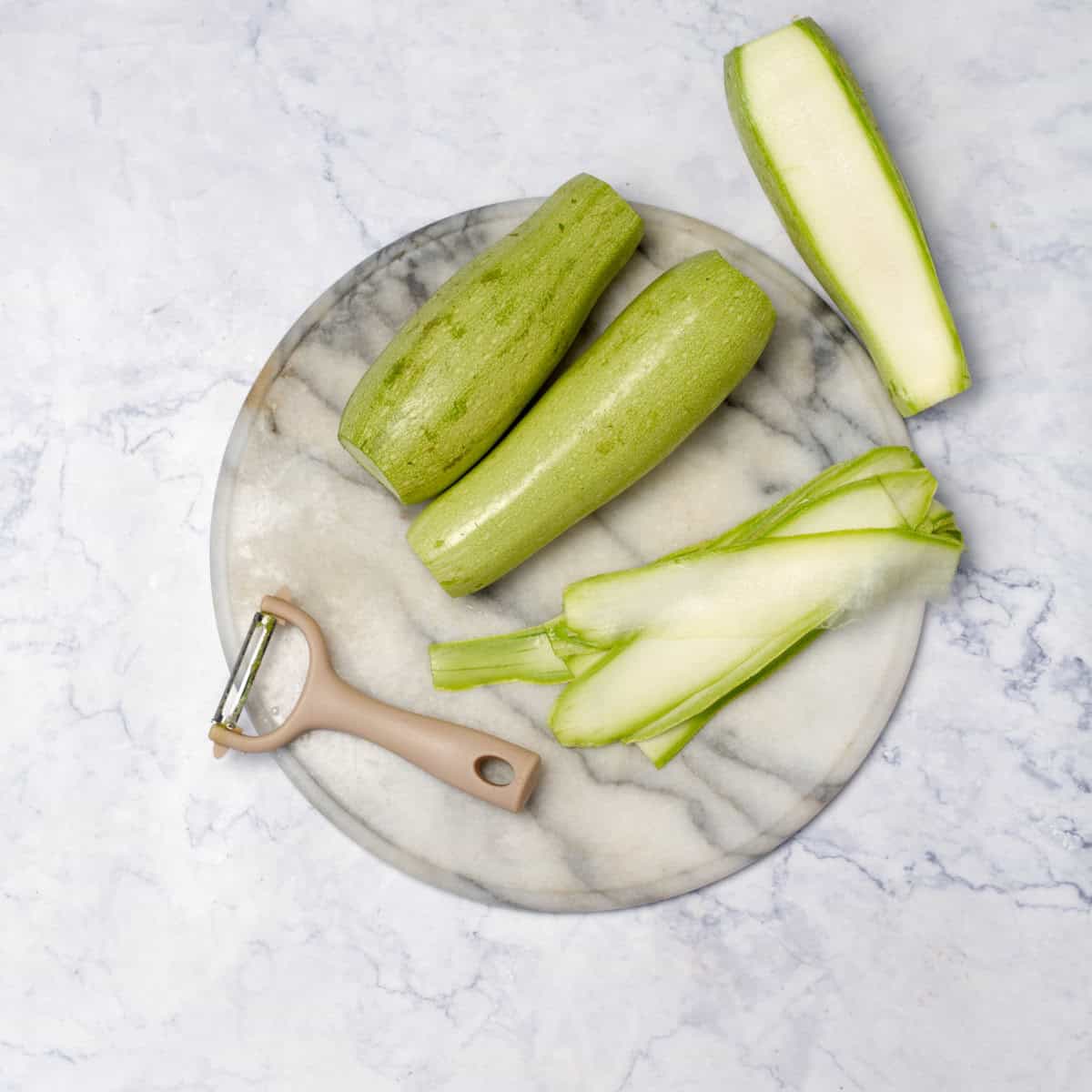 Zucchini placed on board with slicer