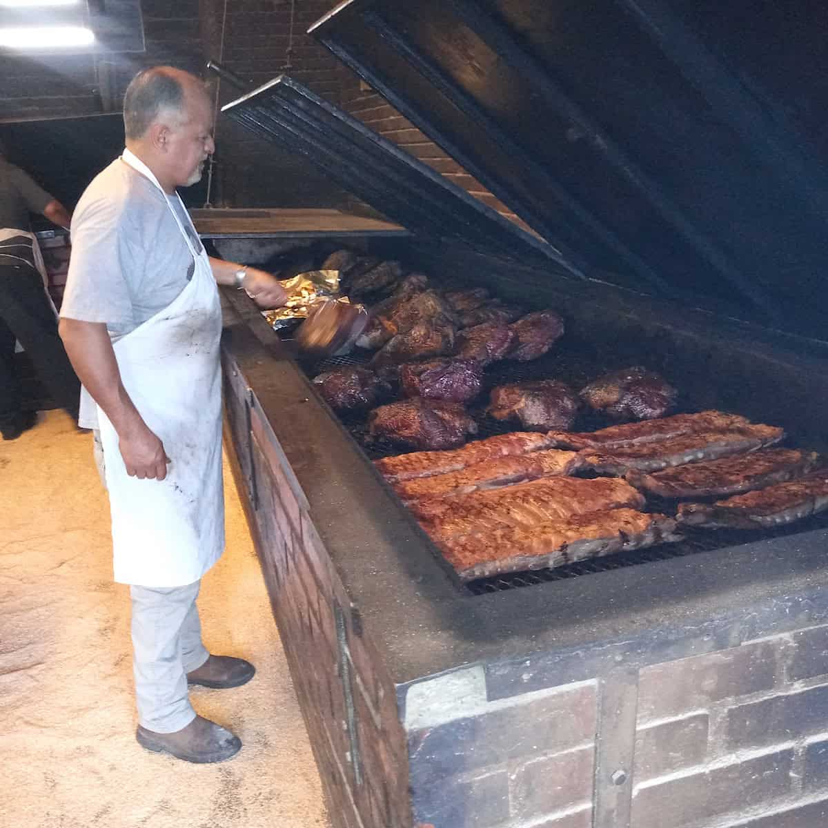 man cooking on giant grill