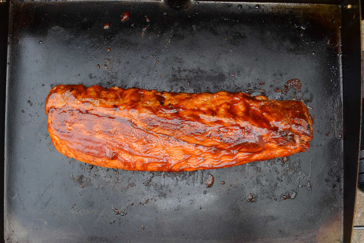 An overhead of the finished and sauced ribs on the griddle 