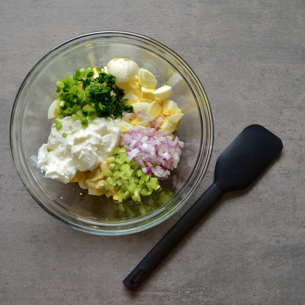 Greek yogurt egg salad ingredients in a bowl