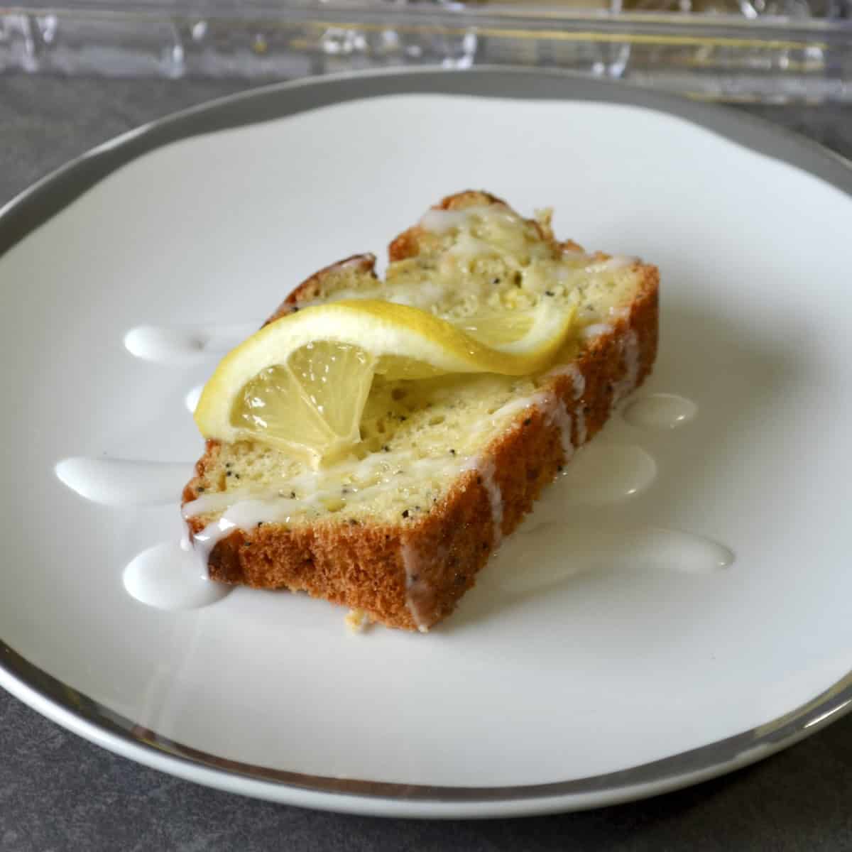 Slice of lemon bread with glaze and lemon slice
